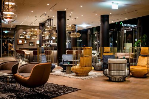 a store with a bunch of chairs in a lobby at Motel One Köln-Messe in Cologne