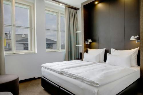 a bedroom with a large bed with white sheets and pillows at Motel One Prague-Florentinum in Prague