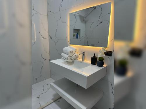 a bathroom with a white sink and a mirror at Marra’s Rooms in Durrës