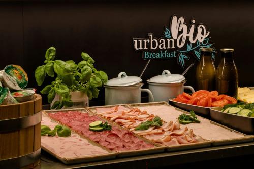 a table topped with different types of meat and vegetables at Motel One Amsterdam-Waterlooplein in Amsterdam