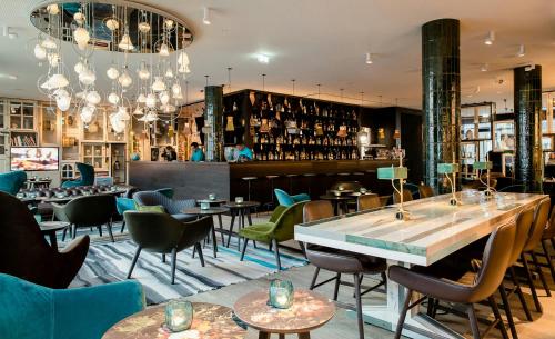 a restaurant with tables and chairs and a bar at Motel One Amsterdam-Waterlooplein in Amsterdam