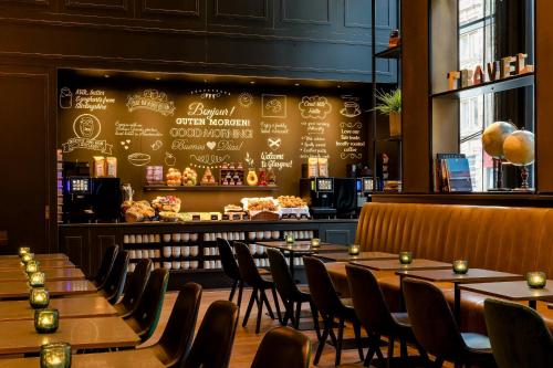 a restaurant with tables and chairs and a bar at Motel One Glasgow in Glasgow