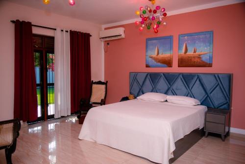 a bedroom with a white bed and a pink wall at Sella Villa-Transit Airport in Seeduwa
