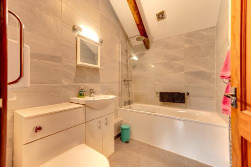 a bathroom with a sink and a tub and a toilet at Kingfisher Cottage at Duffryn Mawr Cottages in Hensol