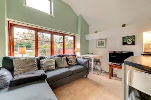 a living room with a couch and a television at Kingfisher Cottage at Duffryn Mawr Cottages in Hensol