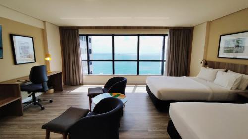 a hotel room with a bed and a large window at Holiday Inn Fortaleza by IHG in Fortaleza