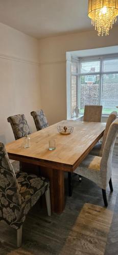 a wooden dining room table with chairs and a chandelier at Sandringham House in Stockton-on-Tees