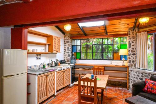 a kitchen with a refrigerator and a table in a room at Casa Aurora Garden Retreat in Ajijic