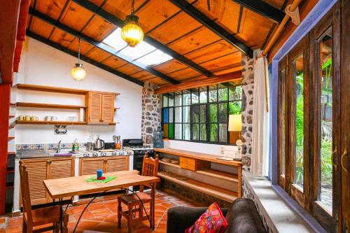 a kitchen and living room with a table and a counter at Casa Aurora Garden Retreat in Ajijic