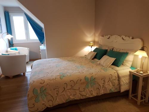 una camera da letto con un letto grande con cuscini verdi di Chambres d'Hôtes La Villa des Hortensias a Berck-sur-Mer