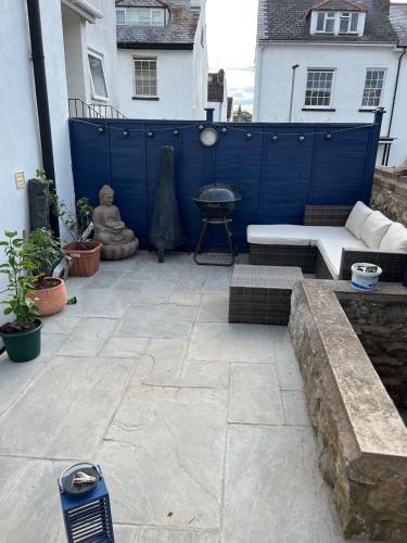 a patio with a bench and a blue fence at Gorgeous Henrietta in Exmouth