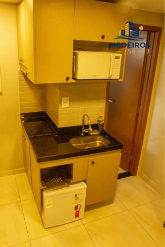 a small kitchen with a sink and a microwave at Apartment 201 / Oceanfront / Mirrored Bed / Kitchen in João Pessoa