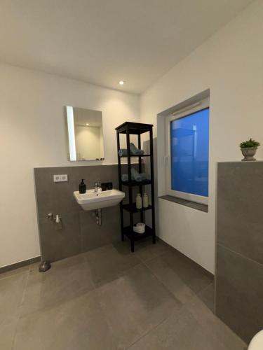 a bathroom with a sink and a mirror at Modernes Dachgeschoss in Augsburg