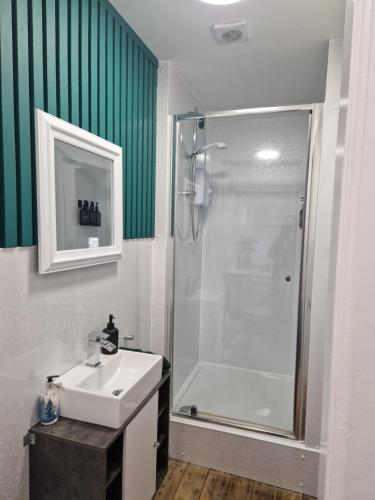 a bathroom with a white sink and a shower at Baile Apartment Central Inverness in Inverness