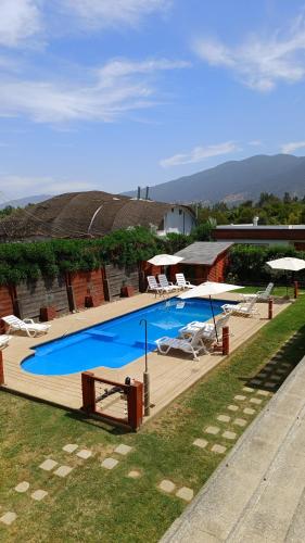 a large swimming pool with chairs and umbrellas at Cabañas Biancomoro Olmue in Olmué
