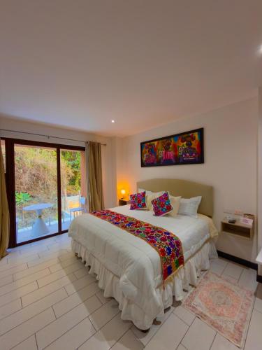 a bedroom with a large bed and a large window at The Madevelyn in Atitlán in Panajachel