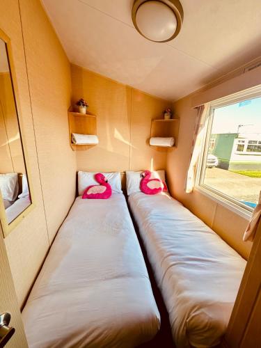 two beds in a small room with a window at Ocean Pearl Home in Heysham