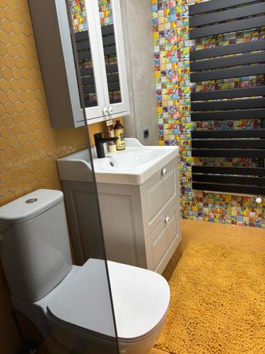 a bathroom with a white toilet and a sink at GZP Residence Lugoj 14 in Lugoj