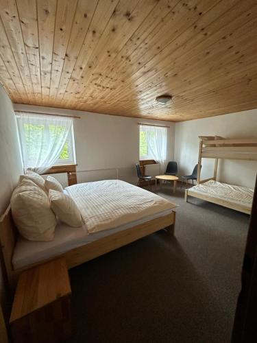 a bedroom with a large bed with a wooden ceiling at Wellness Hotel Zdobnice in Zdobnice