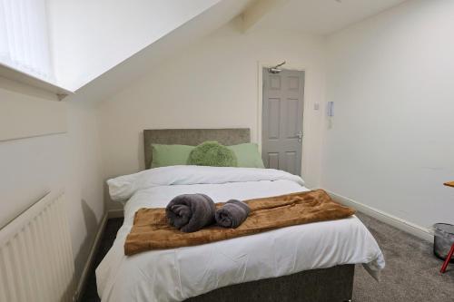 a bedroom with a bed with two towels on it at Elevate suites Darlington in Darlington
