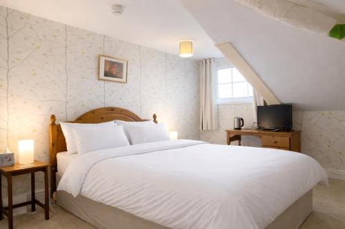 a bedroom with a large white bed and a window at The Manor House in Peel