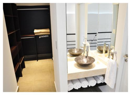 a bathroom with two sinks and a mirror at Apart Maral Zárate in Zárate