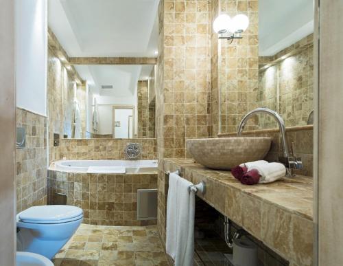 a bathroom with a sink and a toilet and a tub at Hotel Azimut in Sveti Stefan