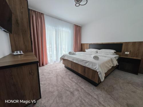 a bedroom with a large bed and a large window at MOFT Borsa in Statjunea Borsa