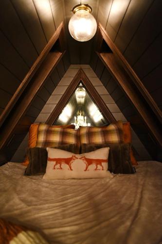 a room with a bed in a attic at Romantic AFrame Cabin with Firepit, BBQ in Pocono Pines