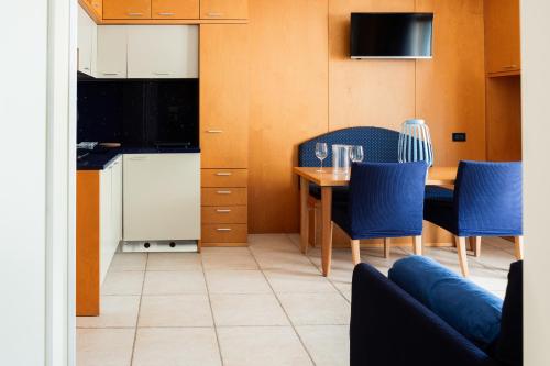 a kitchen and dining room with a table and chairs at Aparthotel Terme Grado - Private Parking in Grado