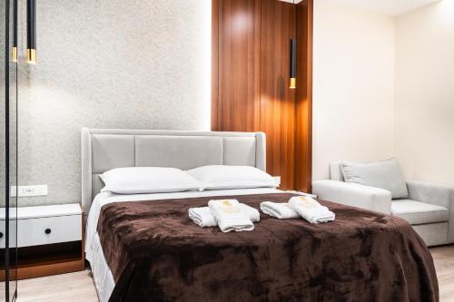 a bedroom with a bed with two towels on it at Luxury City View Apartments with Balcony & Kitchen & Fast Wi-Fi in Shkodër