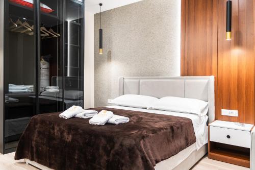 a bedroom with a bed with two towels on it at Luxury City View Apartments with Balcony & Kitchen & Fast Wi-Fi in Shkodër