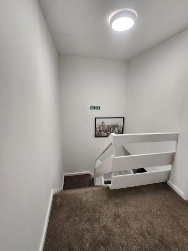 a room with white walls and a stair case at Ensuite premier rooms in Basildon