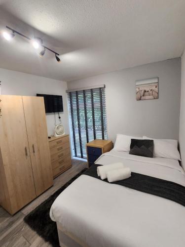 a bedroom with a large white bed and a television at Ensuite premier rooms in Basildon