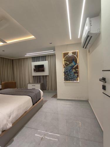 a bedroom with a bed and a painting on the wall at Hotel Red Rose in Vadodara