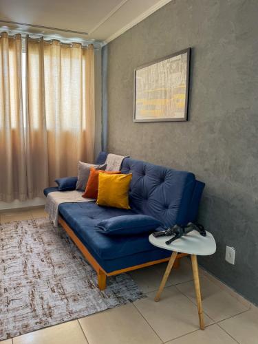 a blue couch in a living room with a table at Apê 302 prox ao SESC in Franca