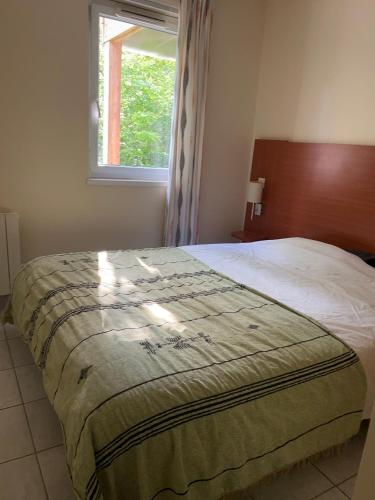 a bedroom with a large bed with a window at Chez Caro in Chaveignes