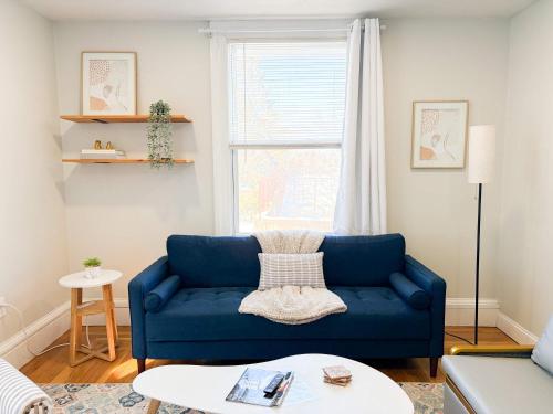 a blue couch in a living room with a window at Jennifer's Cozy Apt Near Brown w In Unit Laundry in Providence