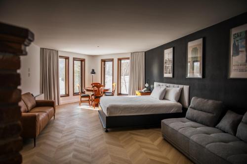 a bedroom with a bed and a couch and a table at Hotel Lac Carling Spa Golf in Harrington