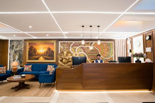 a man sitting at a reception desk in a hotel lobby at Hotel TOS Residency Jubilee hills in Hyderabad