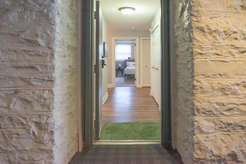 a hallway leading to a room with a stone wall at Lovely CWE 2BR with Private Parking ABODEbucks in Saint Louis