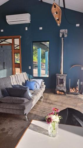a living room with a couch and a wood stove at Refúgio na Serra com Pôr do Sol in Feliz