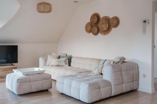 a living room with a couch and a ottoman at Stylish downtown loft and opposite park in Maldegem