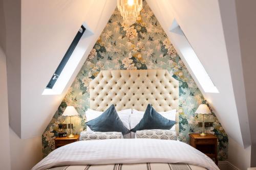 a bedroom with a large bed with a large headboard at The Red Lion Hotel in London
