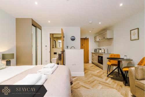 a bedroom with a bed and a kitchen with a table at Rock Mill - Deluxe Apartments with Private Terrace in Stony Middleton