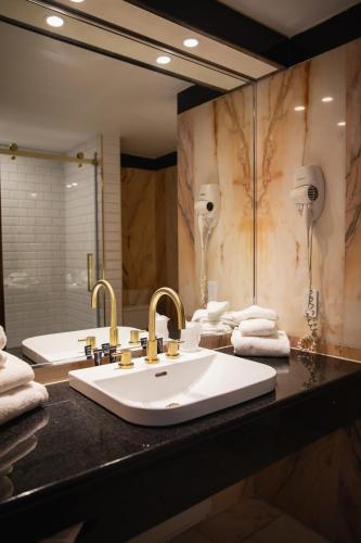 a bathroom with a sink and a large mirror at Hotel Lac Carling Spa Golf in Harrington