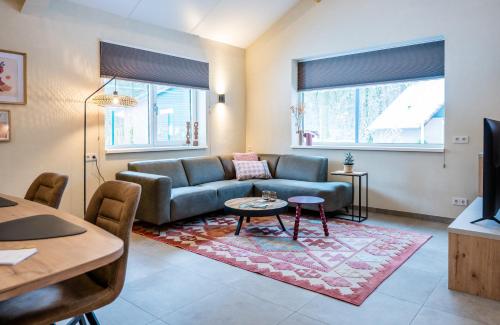 a living room with a couch and a table at Vakantiepark Zevenbergen in Heesch