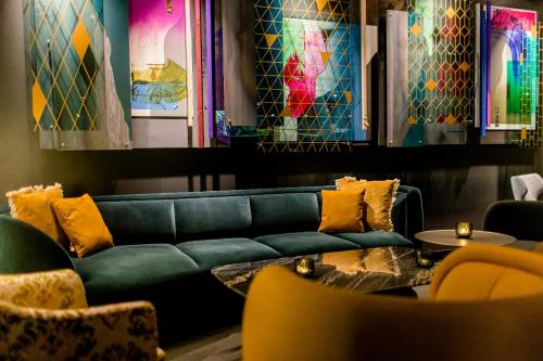 a living room with a green couch and a table at Motel One Berlin-Hackescher Markt in Berlin