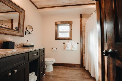a bathroom with a sink and a toilet and a mirror at Teton Valley Resort in Victor
