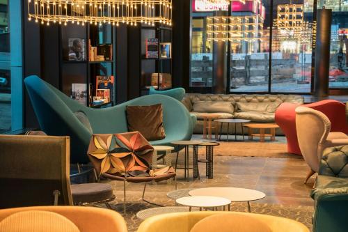 a lobby with couches and tables and chairs at Motel One Berlin-Alexanderplatz in Berlin